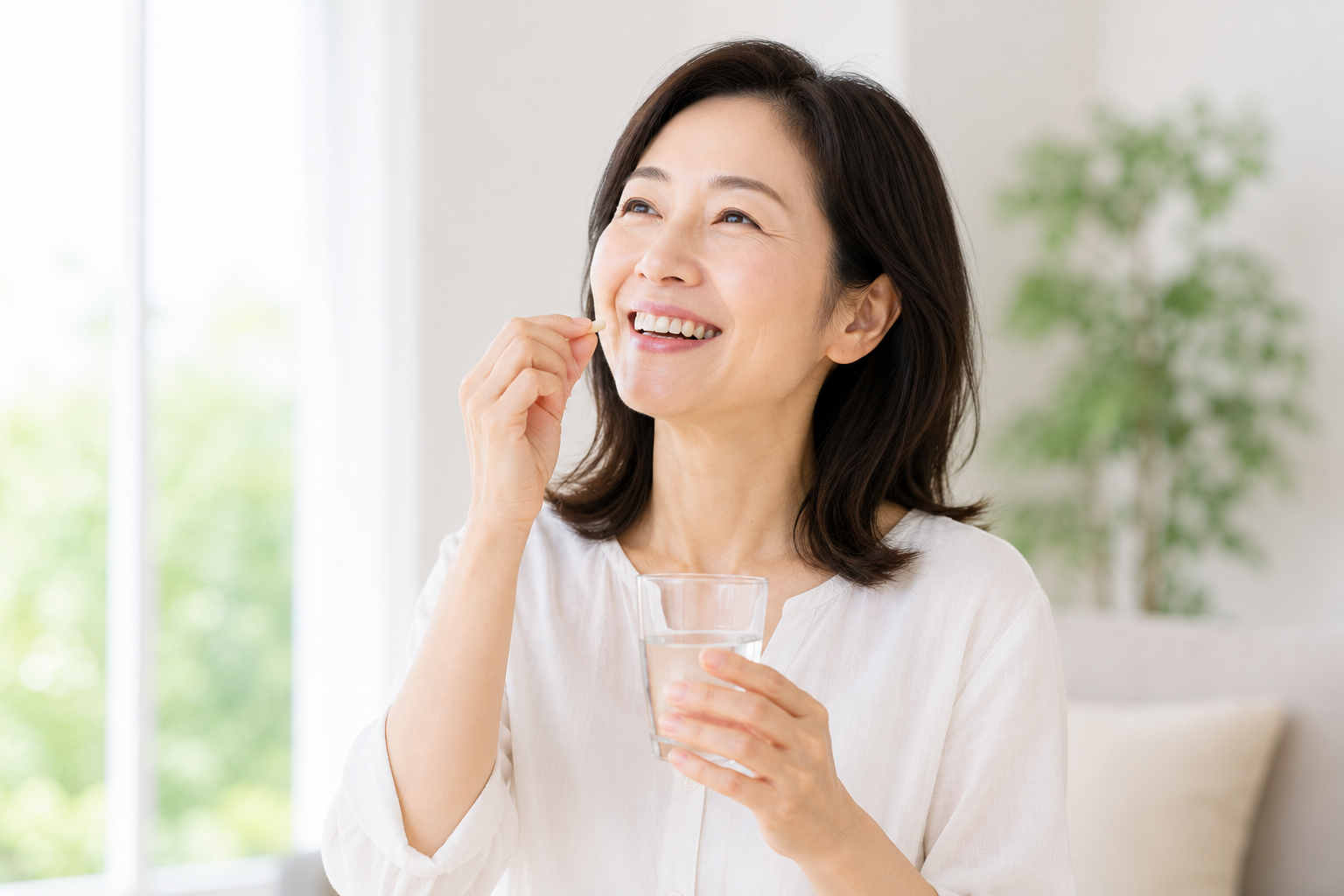 毎日の健康習慣として笑顔でサプリメントを飲む女性